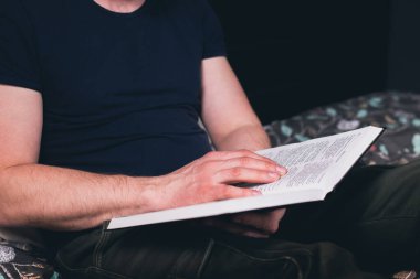 Bir adamın elinde açık bir İncil. Bir adam kutsal kitabı okuyor. Tanrı 'ya dua et.