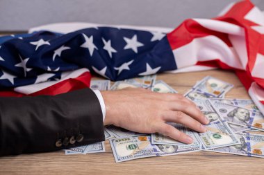 Amerika bayrağı. Arka planda para doları var. ABD 'nin bağımsızlığında ekonomik gücün sembolü. Zenginlik ve finans. Mülkiyet işadamının elinde.