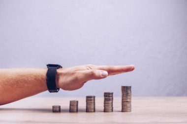 Yükselen madeni paralar yığını. El, faiz yatırımı ekonomisinin sermaye büyümesinin yönünü gösteriyor. Oran artışı. Hisse ve yatırımların büyümesi.