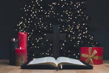 Kutsal İncil 'in açık kitabı. Hediye. Arka planda bir Noel ağacı var. Noel ve Yeni Yıl duası. Geç. İsa 'nın doğumu insanlara olan sevginin bir göstergesidir. Agape.