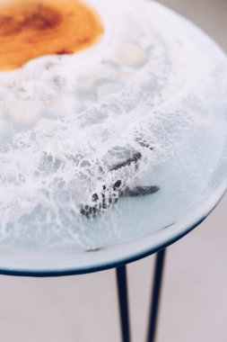 Epoksi reçineden yapılmış bir masa. Deniz masası. Odada mobilyalar var..