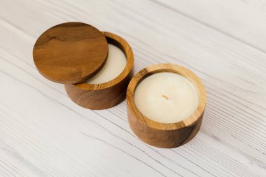 Tahta bir kutuda mum. Beyaz bir masada bir mum..