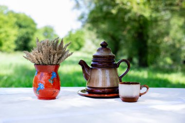 Mutfak tahtasındaki kruvasan. Çaydanlık ve çay kahvesi masanın üstünde. Sürahide bir buket kuru mısır. Sabah kahvaltı ettim.