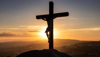 Çarmıha gerilmenin ahşap haçı gökyüzünün arka planında. Gün batımı. Tanrım, Calvary. Hıristiyanlığın sembolü ve günahların affı. Paskalya. İsa doğdu.