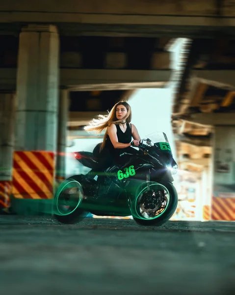 Woman driving her racer motorcycle. Green clouds of smoke from the wheel. Transportation and speed concepts. Rider lady on the move in black clothes speed and acceleration effect, lots of smoke