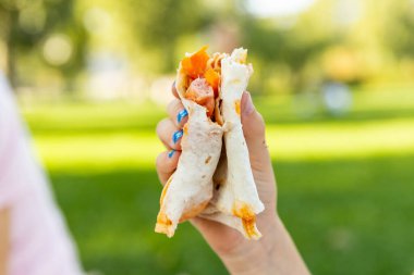 Dışarıdaki yiyeceklerle ilgilenen elleri yakın tutun. El ele tutuşan kız, silme Pita. Sokak yemekleri konsepti