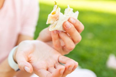 Dışarıdaki yiyeceklerle ilgilenen elleri yakın tutun. Kadın el ele tutuşuyor, Pita. Sokak yemekleri konsepti
