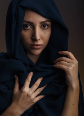 Gündelik giysiler içinde genç Müslüman kadın model ve geleneksel siyah tesettür gülümseyen ve koyu gri arka planda kameraya bakan, kopyalama alanı