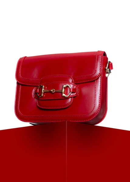 女用红色皮包工作室里红色立方体和白色背景的手提包 带金扣的女式时髦手袋 图库图片