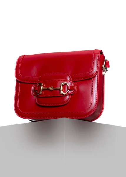 女用红色皮包手提包的现代白色立方体和背景在工作室 带金扣的女式时髦手袋 免版税图库照片