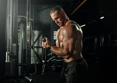 Ağırlıklarla antrenman yapan kaslı adam. Kaba, güçlü atletik adamlar kas egzersizi yapıyor. Vücut geliştirme uzmanı spor salonunda egzersiz yapıyor..