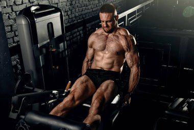 Ağırlıklarla antrenman yapan kaslı adam. Kaba, güçlü atletik adamlar kas egzersizi yapıyor. Vücut geliştirme uzmanı spor salonunda egzersiz yapıyor..