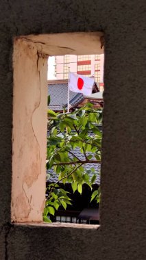 Kitakyushu, Japonya - Mayıs 2025. Kale Duvarındaki Pencere Çerçevesinde Japon Bayrağı