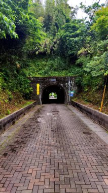 Kitakyushu, Japonya - 26 Mayıs 2025. Aino Adası 'ndaki tünel. İşaretin çevirisi: Tünelin içinde yavaş hareket et