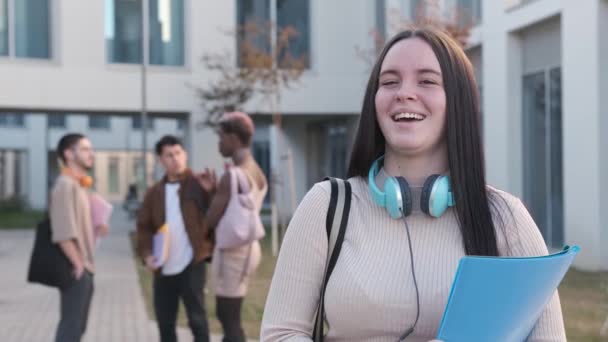 Filmik Szczęśliwą Studentką Uśmiechniętą Kamery Obok Wielonarodowej Grupy Przyjaciół — Wideo stockowe