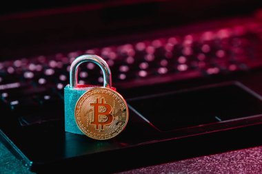 Altın bitcoin ve küçük asma kilit güvenli kripto para ticaretinin sembolü olarak netbook klavyesine yerleştirildi