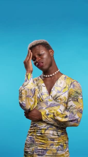穿着时髦衣服的非洲变性人在患有蓝色背景偏头痛时揉搓额头和眨眼 — 图库视频影像