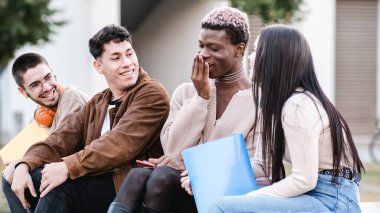 Saçları boyalı, neşeli siyah transseksüel öğrenci tezgahta oturup dersten sonra çeşitli sınıf arkadaşlarıyla sohbet ederken ağzı şaşkın bir şekilde kapanıyor.