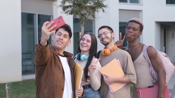 身着休闲装 手持照片的西班牙年轻人在大学毕业后 用智能手机与多种族同学合影 脸上挂着鬼脸 还摆出V字形 — 图库视频影像