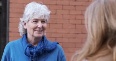 Sokakta konuşan iki yaşlı kadının yavaş çekim videosu.