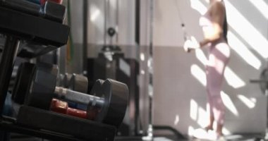 Spor kıyafetleri içindeki tanınmayan genç bayan sporcunun spor salonunda güneşli bir günde halatla anonim sporcunun yanında halat çekerken yandan görünüşü.