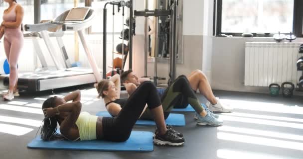 身强力壮的多种族男女穿着运动服躺在垫子上 一起在轻便体育馆做腹肌锻炼 — 图库视频影像