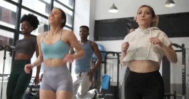 Spor salonunda antrenman yaparken spor yapan bir grup fitness insanı atlayıp antrenörü takip ediyor. Spor ve aktif yaşam tarzı kavramı.