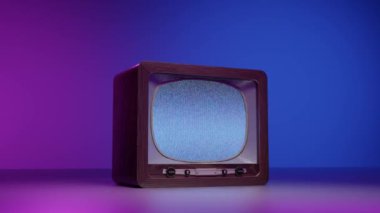 Mor ve mavi neon aydınlatmaya karşı beyaz gürültülü kahverengi renkli televizyonun gerçek zamanlı yansıması.