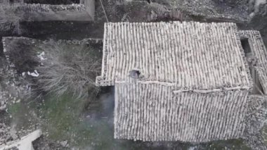 Sıcak, dumanlı bacanın yukarısından bambu çatılı ve eski moda ahşap evlerin duvarlarından pejmürde duvarlar ve günbatımında çimen