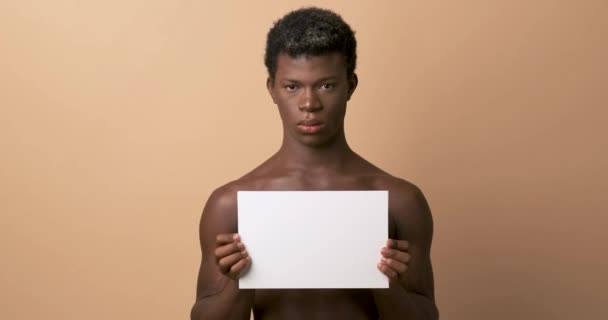 Video Estudio Una Seria Persona Transgénero Africana Sosteniendo Panel Blanco — Vídeo de stock