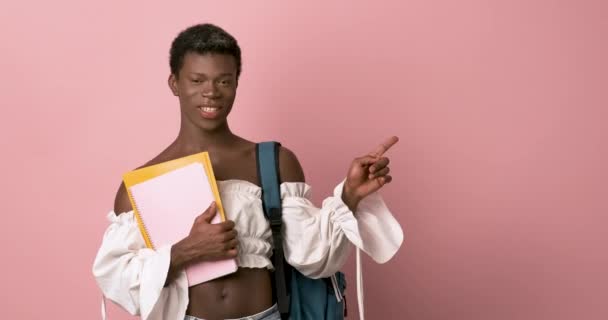 Unga Positiva Afroamerikanska Transpersoner Med Ryggsäck Håller Copybooks Och Pekar — Stockvideo