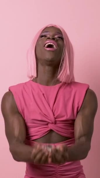 年轻快乐健壮的非洲裔美国人带着粉色假发 身穿节日彩衣 一边在演播室里跳舞 一边笑 慢动作 — 图库视频影像