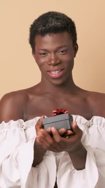 Видео Студии Трансгендерного Африканца Дарящего Подарок Человеку Бежевом Фоне — стоковое видео