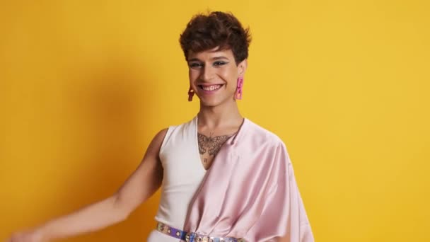 Pembe Elbiseli Transseksüel Bir Adamın Videosu Sarı Arka Planda Kameraya — Stok video