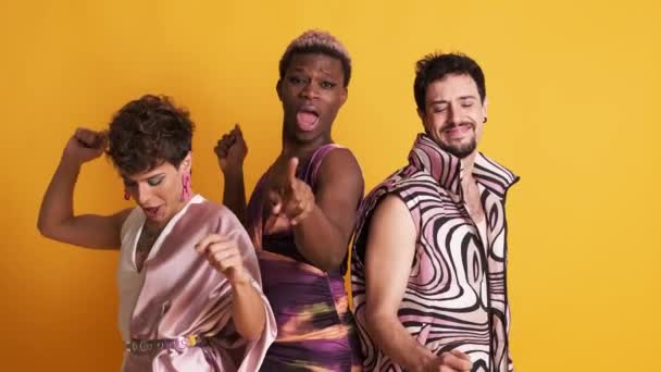 三个快乐的多种族跨性别男人在黄色背景下快乐地跳舞的视频 — 图库视频影像