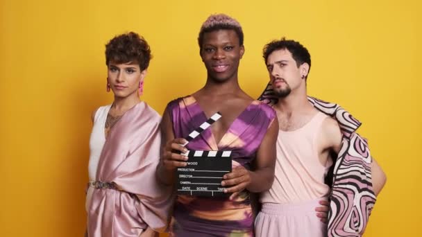 フィルムクラッパーボードでポーズするトランスセクシャルモデルの多民族グループのビデオ — ストック動画