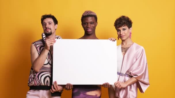 黄色の背景に白い空のパネルを一緒に保持する3人の多民族性男性のビデオ — ストック動画