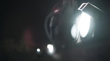 Karanlık bir gecede tren farlarının yakın plan çekimi, tren hareketsiz, yumuşak bir hareketle