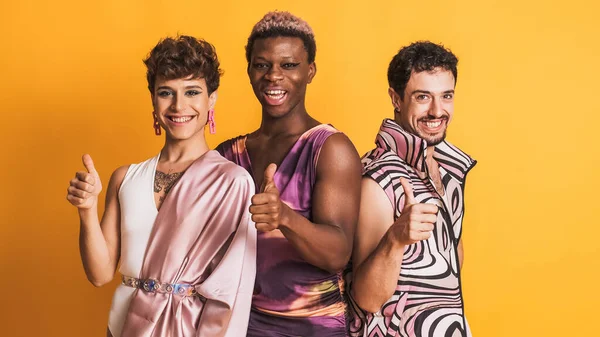 three multiethnic transgender men gesturing to be fine with the thumb up while posing in a photographic studio