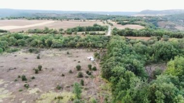 İspanya 'da açık gökyüzünün altında yeşil yemyeşil ağaçların büyüdüğü pitoresk manzaralı karavan hava aracı görüntüsü.