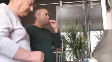 Evde uyandıktan sonra dişlerini ve yüzünü temizleyen eşcinsel bir çiftin videosu.