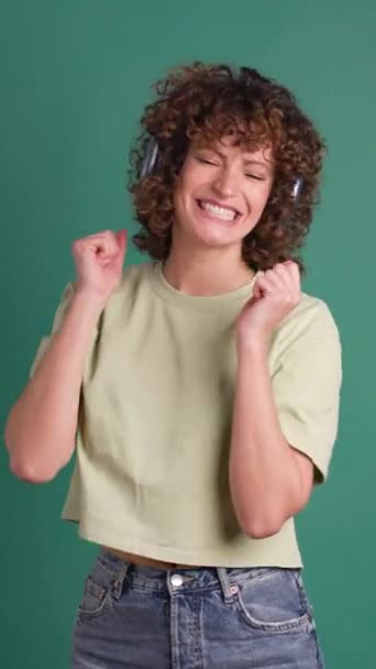 Mujer Adulta Bailando Con Auriculares Peinado Rizado Fondo Verde Estudio — Vídeo de stock