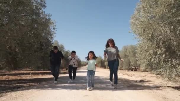 農村の道を走りながら遊ぶ非正常な幸せな家族のスローモーションビデオ — ストック動画