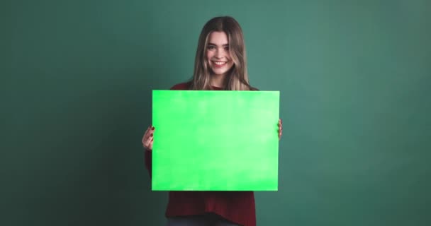 Жінка Тримає Зелену Хромову Панель Посміхається Студії Зеленим Фоном — стокове відео