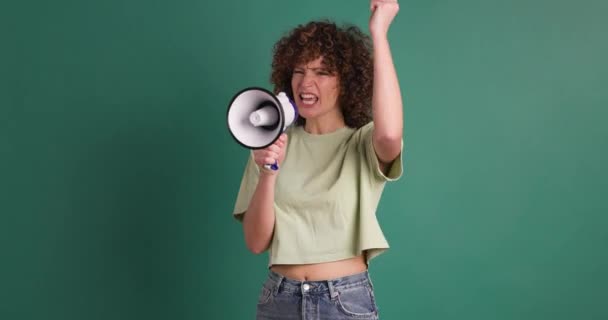 Kıvırcık Saçlı Yeşil Arka Planda Dururken Megafonla Bağıran Neşeli Genç — Stok video