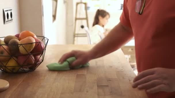 Vídeo Mão Homem Limpando Superfície Madeira Cozinha Lado Sua Família — Vídeo de Stock