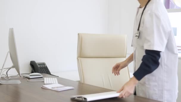 年轻的女医生走进诊所 坐在电脑前的椅子上准备开始工作 — 图库视频影像
