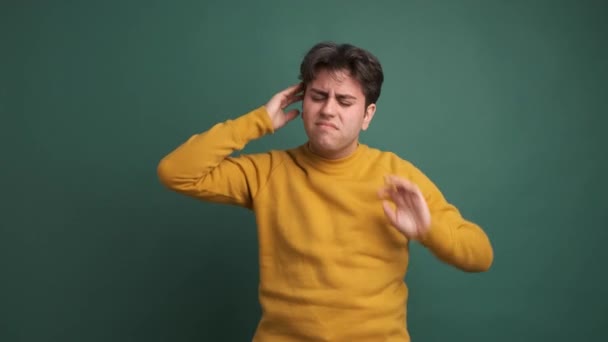 Sarı Kıyafetli Düşünceli Genç Bir Erkek Yeşil Arka Planda Baş — Stok video