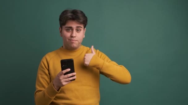 Retrato Feliz Hispânico Jovem Macho Amarelo Roupa Segurando Smartphone Enquanto — Vídeo de Stock