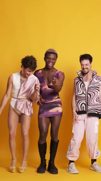 Видео Фотостудии Жёлтым Фоном Трех Счастливых Трансгендерных Мужчин Танцующих Веселящихся — стоковое видео